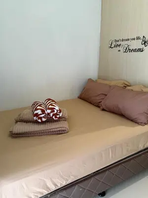 a bed with two pillows and a sign on the wall at Sea Residences at Rose stayction in Manila