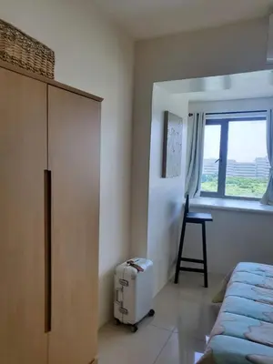 a bedroom with a bed and a chair and a window at Barkada Room by Metro Staycation in Manila