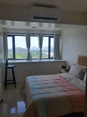 a bedroom with a large bed and a window at Barkada Room by Metro Staycation in Manila