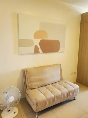 a living room with a couch and a fan at Barkada Room by Metro Staycation in Manila