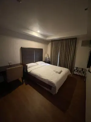 a bedroom with a large bed and a window at A venue Residences Tower 10i in Manila