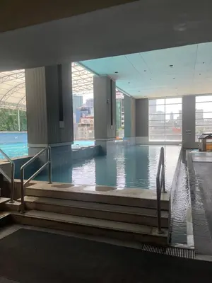 a large indoor swimming pool with water in a building at A venue Residences Tower 10i in Manila