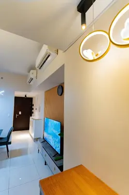 a living room with a tv on a wall at 3BR Modern Uptown Parksuites BGC with bathtub in Manila
