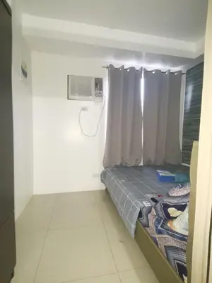 a room with a bed and a air conditioner at Shore by Metro Staycation in Manila