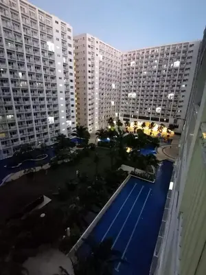 an aerial view of a large building with a swimming pool at Shore by Metro Staycation in Manila