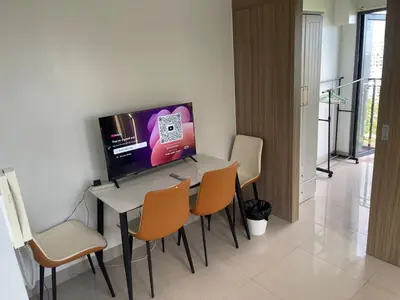 a dining room with a table with chairs and a tv at Shore 2 Residences MOA NAIA in Manila