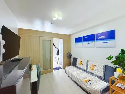 a living room with a couch and a tv at Shore 1 tower c1 17floor near moa facing swimming pool in Manila
