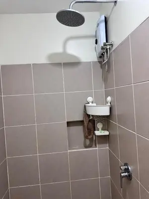 a bathroom with a shower with a phone on the wall at Emmanuel's Lair Prisma Residences in Manila