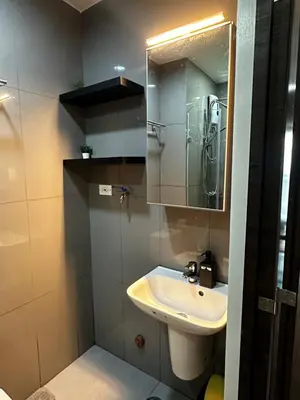 a bathroom with a sink and a mirror at Air Residences with 500Mbps Wifi in Manila