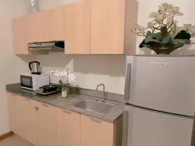 a kitchen with a white refrigerator and a sink at Casa Josefina in Manila