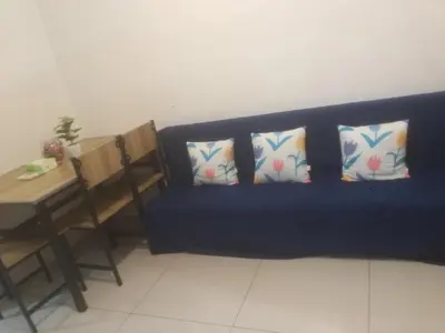 a blue couch with four pillows and a table at Staycation at MALL OF ASIA -by Tess Ualat in Manila