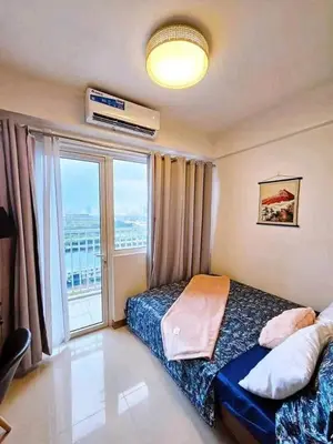 a bedroom with a bed and a large window at Sabrina Staycaytion in Manila