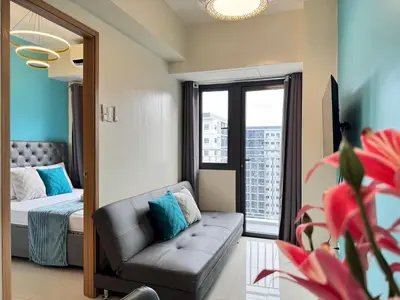 a bedroom with a bed and a couch and a mirror at Shore 3 Residences Room 1659 infront of SM MOA in Manila