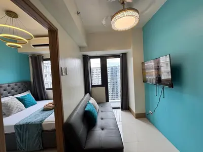 a small room with a bed and a couch in it at Shore 3 Residences Room 1659 infront of SM MOA in Manila