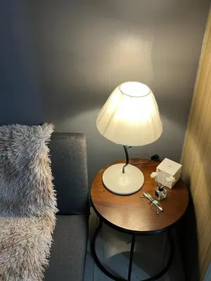 a table with a lamp on it next to a chair at Bay stays at shore residence in Manila