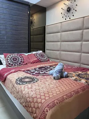 a bedroom with a large bed with a large headboard at EaseStay by Bren in Shell Residences MOA in Manila