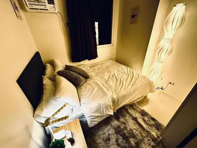 a small bed in a small room with a window at Exquisite 2 Bedroom Suite in Manila