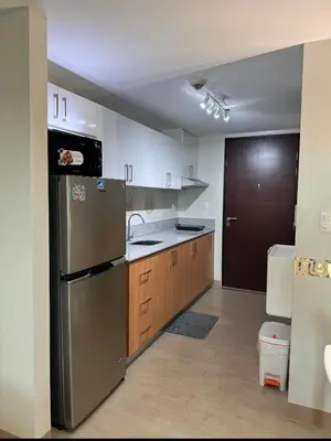 a kitchen with a stainless steel refrigerator and wooden cabinets at Manhattan's Place in Manila