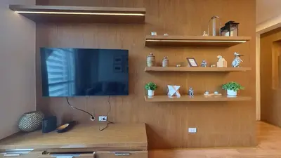 a living room with a flat screen tv on a wall at Full-Serviced Residential Apartment in Blue Sapphire, BGC in Manila