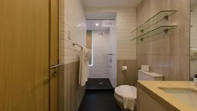 a bathroom with a toilet and a sink and a shower at Full-Serviced Residential Apartment in Blue Sapphire, BGC in Manila