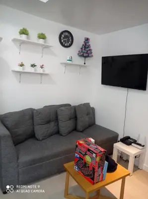 a living room with a gray couch and a tv at Azure Condo by arlene in Manila