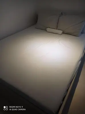a bed with white sheets and a pillow on it at Azure Condo by arlene in Manila