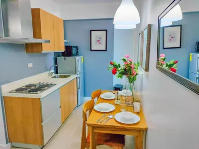 a kitchen with a table with plates and flowers on it at Azure place by arlene in Manila