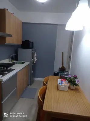 a kitchen with a wooden table and a counter top at Azure place by arlene in Manila
