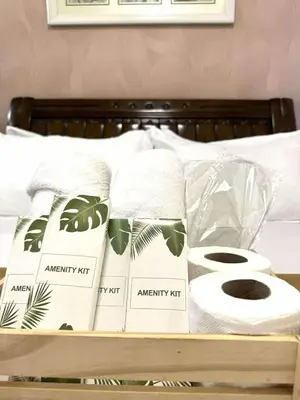 a tray with towels and toilet paper on a bed at Azure Urban Resort by Tallia & Tiffany in Manila