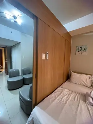 a bedroom with a bed and a chair and a mirror at 1bedroom Pool view 1441 shell residence with balcony in Manila