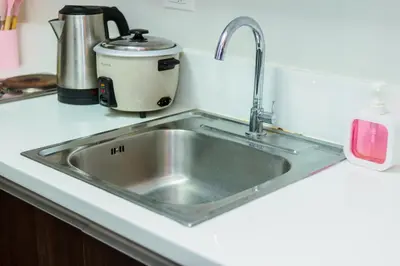 a kitchen sink with a toaster sitting next to it at Air Dream Den Good Vibes Makati Gym Swim Park Superfast Internet 3870 in Manila