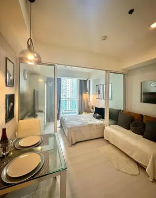 a living room with a bed and a couch at Beach Condo at Azure Urban Resort with SmartTV in Manila