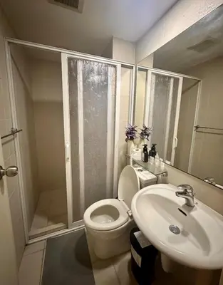 a bathroom with a shower and a toilet and a sink at Beach Condo at Azure Urban Resort with SmartTV in Manila