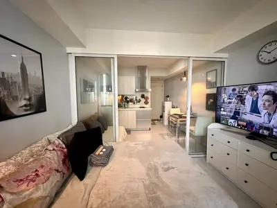 a living room with a large flat screen tv at Beach Condo at Azure Urban Resort with SmartTV in Manila