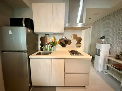 a small kitchen with a sink and a refrigerator at Beach Condo at Azure Urban Resort with SmartTV in Manila