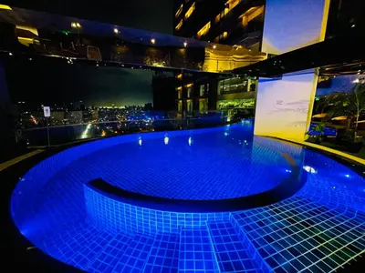 a swimming pool on top of a building at night at The Gramercy Residences NEW Sleek 1BR Suite, 600mbps Wifi, Netflix & FREE Amenities in Manila