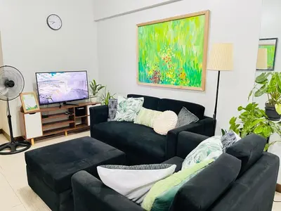a living room with two couches and a tv at Acacia Estates' The Getaway Taguig, Evergreen in Manila