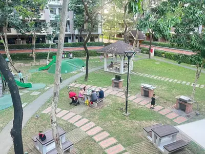a group of people sitting at a park with a playground at Acacia Estates' The Getaway Taguig, Evergreen in Manila