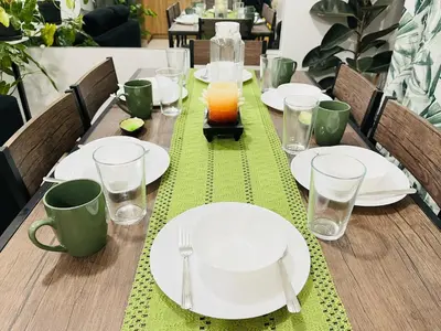 a wooden table with plates and glasses on it at Acacia Estates' The Getaway Taguig, Evergreen in Manila