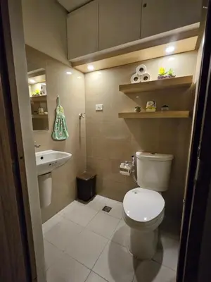 a small bathroom with a toilet and a sink at Soleil Suite 10 mins to SM Moa, Pasay - 2 beds in Manila