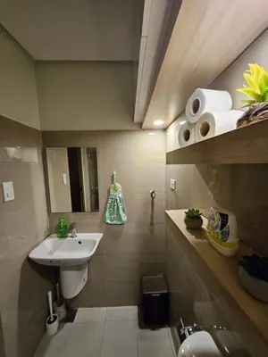 a small bathroom with a sink and a mirror at Soleil Suite 10 mins to SM Moa, Pasay - 2 beds in Manila