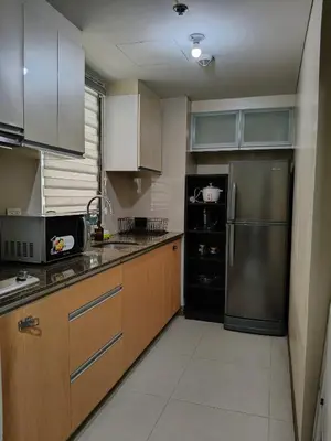 a kitchen with wooden cabinets and a stainless steel refrigerator at LDN Secret 1BR across NAIA Terminal 3 in Manila