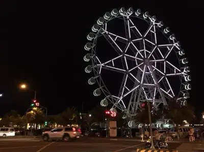 a large ferris wheel in a parking lot at night at Staycation at SHORE 1005 in Mall of Asia near Airport in Manila
