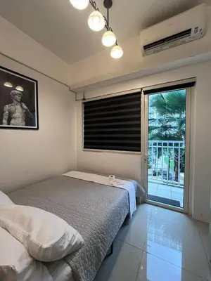 a bedroom with a bed and a large window at Biglaang Lakad by Metro Staycation in Manila