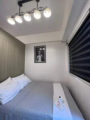 a bedroom with a bed and a picture of a man at Biglaang Lakad by Metro Staycation in Manila