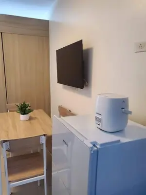 a kitchen with a slow cooker and a tv on the wall at Barkada Pamilya BnB by Metro Staycation in Manila