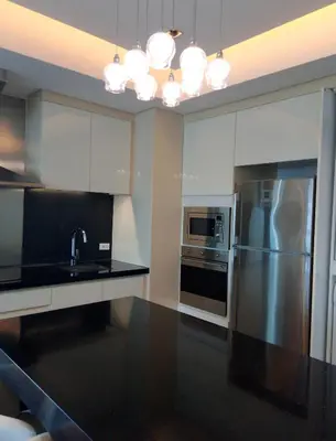 a kitchen with white cabinets and a stainless steel refrigerator at Alphaland Suites Apartment Hotel in Manila
