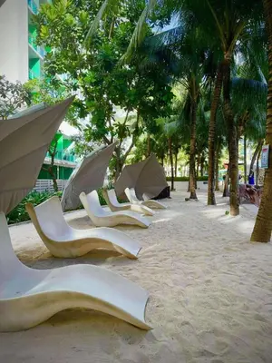 a row of chairs and umbrellas on a beach at Azure Resort Residence, 1bedroom with balcony Beach view in Manila