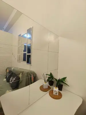 a living room with a couch and a mirror at Group Stay by Metro Staycation in Manila