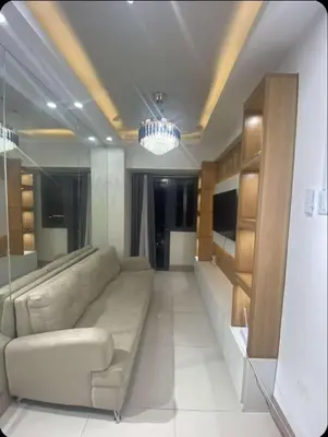 a living room with a couch and a chandelier at Comfort Cove at Shore 3 in Manila
